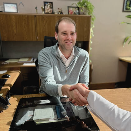 Cameron shaking a customer's hand