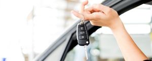 Hand holding new keys implying a new car purchase