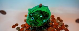 Picture of a green CTC piggy bank surrounded by coins